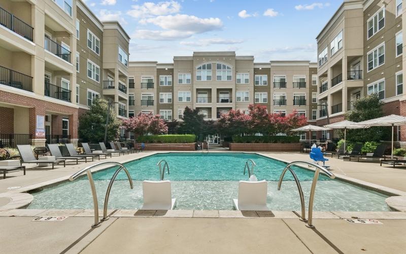 a pool in a courtyard with buildings in the background