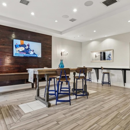 a clubroom with a tv, tables and chairs