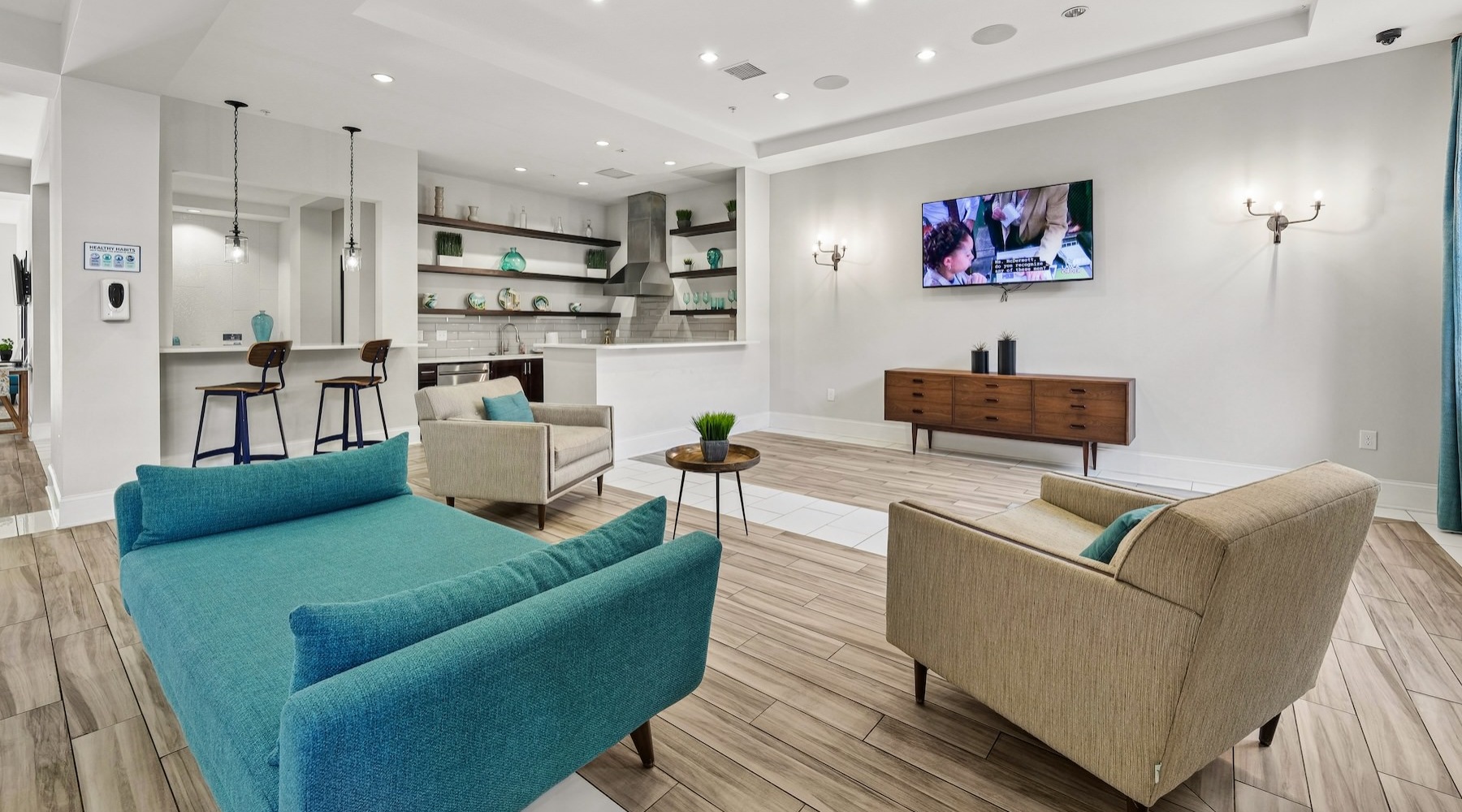 a clubroom with a tv, couch and chairs